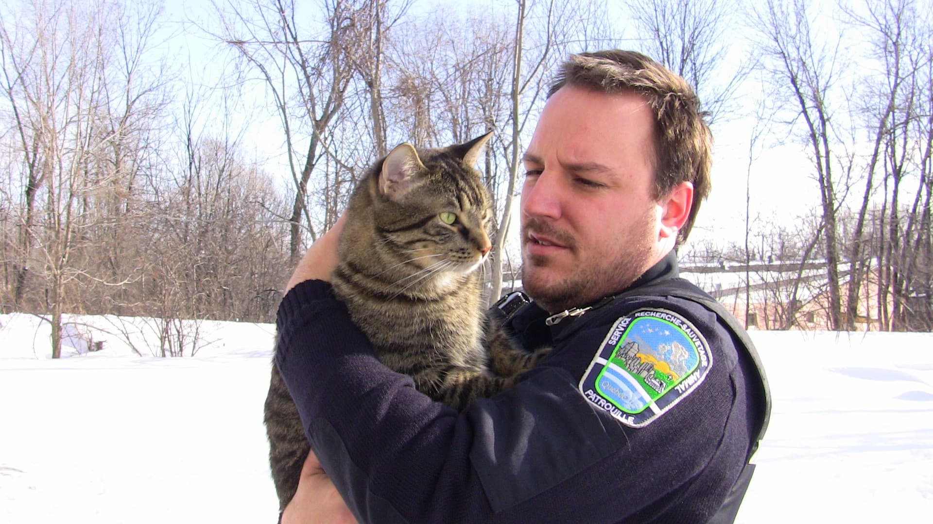 Eric Dussault tenant un chat dans la neige, à l'époque de la fondation