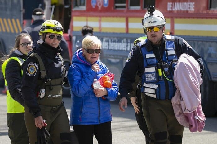 Intervenants escortant une résidente évacuée à Sainte-Marthe-sur-le-Lac