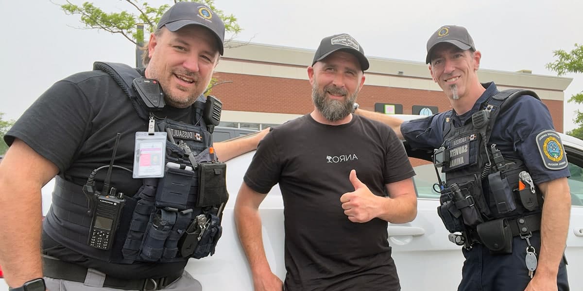 Trois intervenants souriants devant un véhicule de Sauvetage Animal Rescue